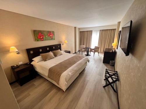 a bedroom with a large bed and a television at Howard Johnson by Wyndham Funes in Funes