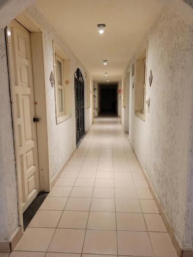 an empty hallway with white walls and tile floors at Hotel Dulce Luna in San Cristóbal de Las Casas