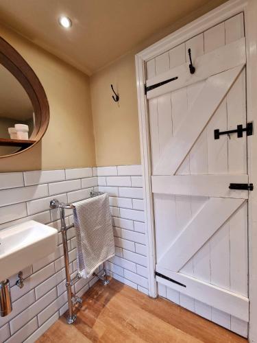a bathroom with a sliding barn door and a sink at Bluebird Cottage in Pickering