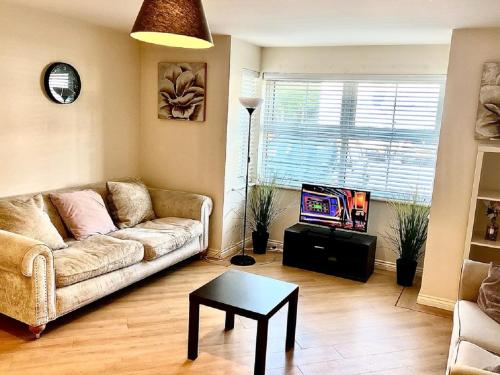 ein Wohnzimmer mit einem Sofa, einem Tisch und einem TV in der Unterkunft Chancellor Court Apartment in Liverpool