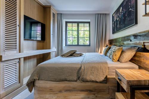 a bedroom with a bed and a table and a window at Castro Mesembria Boutique Hotel in Nesebar