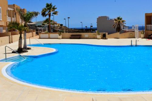a large blue swimming pool on top of a building at Amazing Ocean View Apartment in Poris de Abona