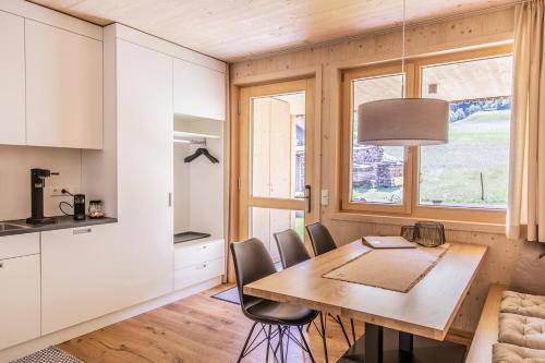 a kitchen and dining room with a wooden table and chairs at Wasserfall Apartments Mellau in Mellau