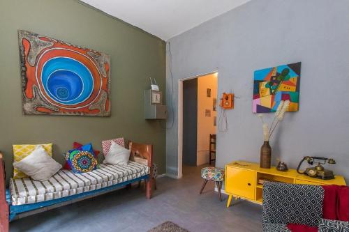 a living room with a couch and a painting on the wall at Hospedaria da Mama in Sao Paulo