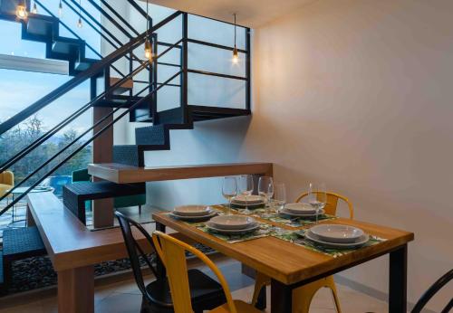 a dining room with a table with chairs and a staircase at MIRADORES DEL SUSANA DUPLEX I in Ushuaia