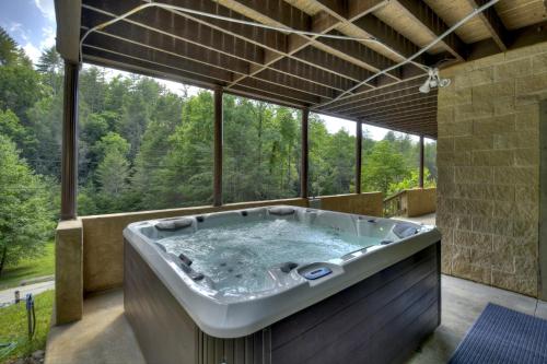 a jacuzzi tub in a room with a view at The Chariot - Creek Front with HotTub, Fire Pits, Billiards, EV Charger - Sandalwood Stays in Blue Ridge