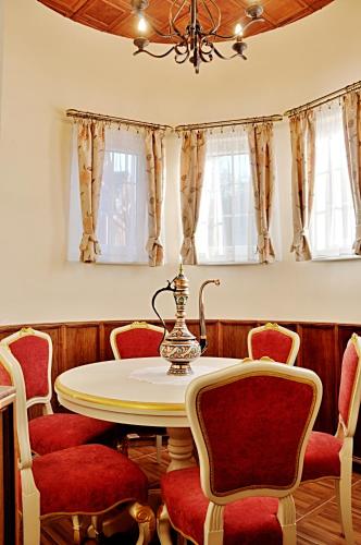 a dining room with a table and red chairs at Zámeček Kaliště in Poddubí