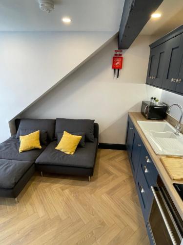 a couch with two yellow pillows in a kitchen at Roe Valley Apartments in Limavady