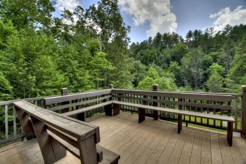 a wooden deck with two benches on top of it at The Chariot - Creek Front with HotTub, Fire Pits, Billiards, EV Charger - Sandalwood Stays in Blue Ridge