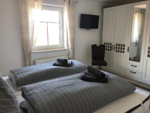 2 camas individuales en una habitación con ventana en Greetje Oog, en Krummhörn