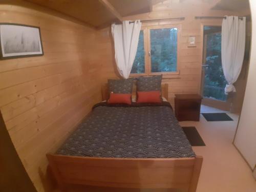 1 dormitorio pequeño con 1 cama en una casa pequeña en Chalet Ekowün, en Payrignac
