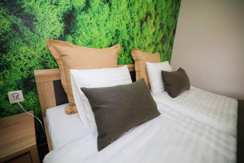 a bedroom with two beds and a green wall at Greenland Apartments in Cēsis