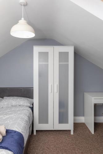 a bedroom with a white cabinet and a bed at Middlesbrough Town Centre Double Private Rooms in Middlesbrough
