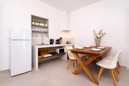 a kitchen with a wooden table and a white refrigerator at Villa Echedra in Vlychada