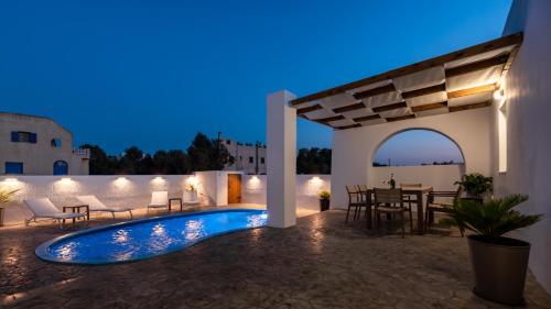 a villa with a swimming pool at night at Villa Echedra in Vlychada