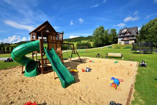 a playground with a slide in the sand at Willa Zielona Polana in Czarna Góra