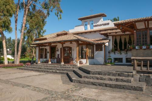 a building with stairs in front of a building at Hotel Hacienda Abraspungo in Riobamba