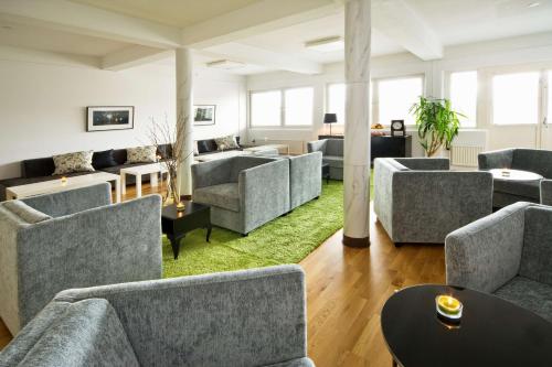 a waiting room with couches and tables at Sure Hotel by Best Western Ojaby Herrgard in Växjö