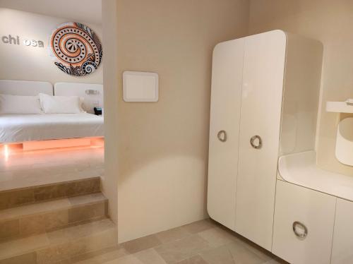 a small room with a bed and a white cabinet at Palazzo Gatto Art Hotel & SPA - BW Premier Collection in Trapani
