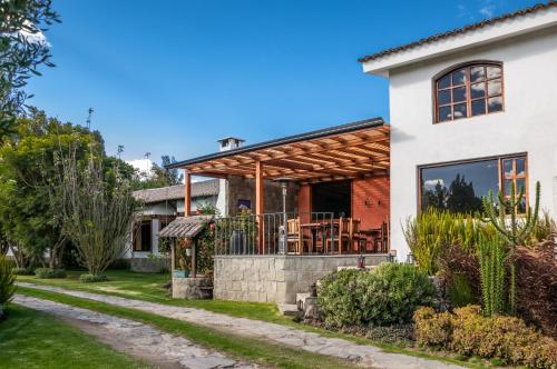 a house with a porch with a patio at Hotel Hacienda Abraspungo in Riobamba