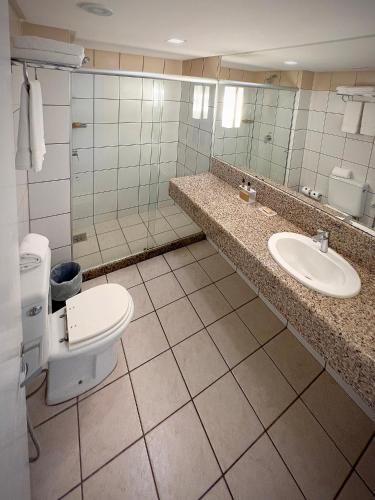 a bathroom with a toilet and a sink at Bourbon Hotel Fortaleza in Fortaleza