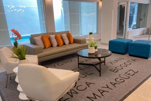 sala de estar con sofá, sillas y mesa en TRYP by Wyndham Mayaguez en Mayagüez