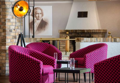 a room with pink chairs and a table at Best Western Parkhotel Brehna-Halle in Brehna