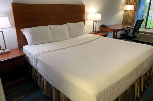 a large white bed in a hotel room at Travelodge by Wyndham Mobile AL in Mobile