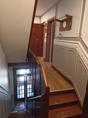 a staircase in a house with wooden floors and a door at Au Coeur d'Acren in Lessines