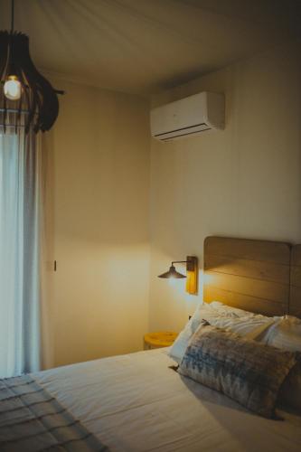 a bedroom with a bed and a window at Peri Elxis Luxury Suites in Mouresi