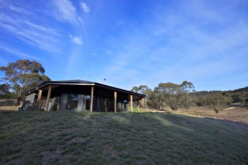 a small house on a hill with a grassy field at Snowy Wilderness in Ingebyra