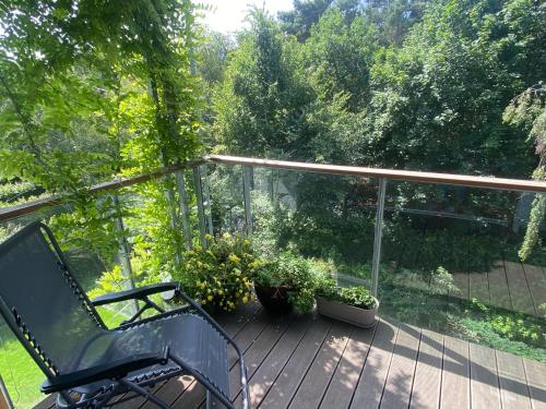 a black bench sitting on a deck with plants at Apartament Nadmorski Dwór- Gdańsk in Gdańsk