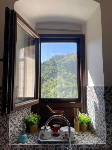 a kitchen window with a view of a mountain at Rodanthe's Guest House in Stemnitsa