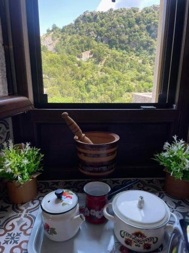 a table with a window with a view of a mountain at Rodanthe's Guest House in Stemnitsa