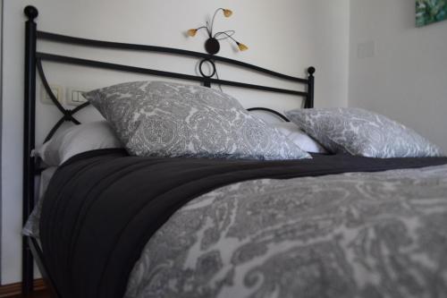 Una cama con almohadas grises y blancas. en Holiday Home Ribno - Bled, en Bled