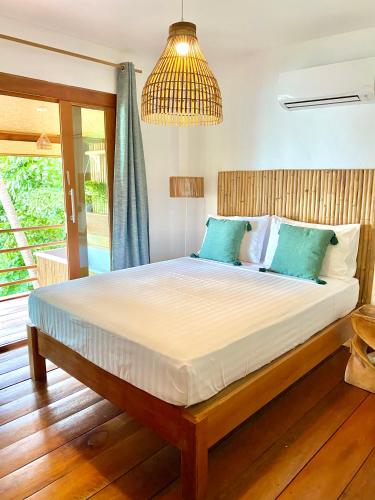 a bedroom with a large bed with blue pillows at Kalulushi Bungalows in Haad Pleayleam