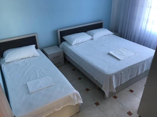 a bedroom with two beds with white sheets at Sea View Apartment Shkëmbi i Kavajes in Durrës