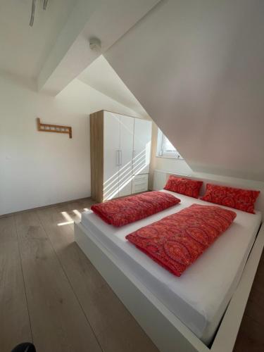 a bedroom with a large bed with red pillows at Ferienwohnung in Lonsee-Ettlenschieß in Lonsee
