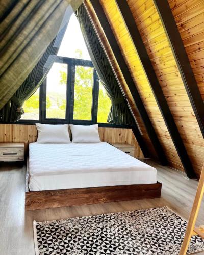 Bett in einem Zimmer mit einem großen Fenster in der Unterkunft KARYA BUNGALOV VİLLA in Dalaman