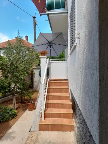 eine Treppe mit einem Regenschirm auf einem Haus in der Unterkunft Apartment Gotovina Biograd na Moru in Biograd na Moru