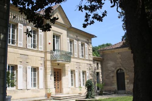 duży kamienny budynek z balkonem w obiekcie Malis Castera Le Petit Château w mieście Saint-Jean-de-Blaignac