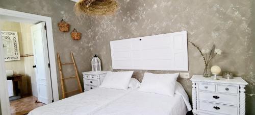 1 dormitorio con 1 cama blanca y vestidor blanco en Preciosa casa de pueblo entre Ronda y Setenil La Posada de Catalina en Montecorto