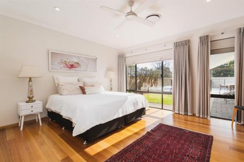 a bedroom with a bed and a large window at The Lodge - Dunsborough in Dunsborough