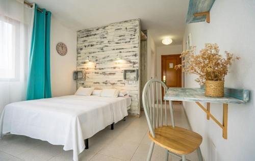 a bedroom with a white bed and a table at Hotel Los Narejos in Los Alc&aacute;zares