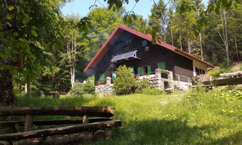 una cabaña de madera en el bosque con una valla en Kod Slaveka, en Kostanjevac