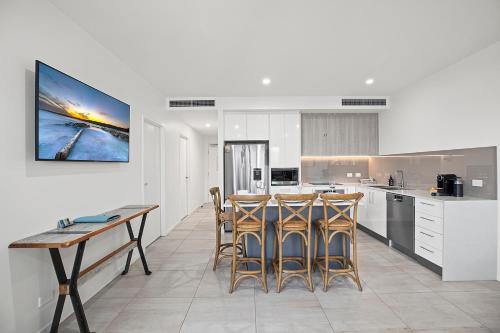 a kitchen with a table and chairs in a room at Rockpool 2 Sawtell Beach - Just steps to Restaurants and 2 min Stroll to Beach! in Sawtell