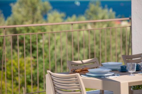 una mesa con tazones y platos en el balcón en Ionian Sunshine Villas, en Paleros