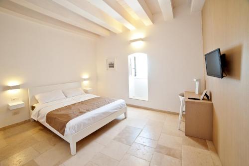 a bedroom with a bed and a flat screen tv at MoMa B&B Molfetta Mare in Molfetta