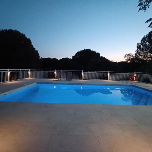 a swimming pool at night with a fence at Viña Concepción in Andújar