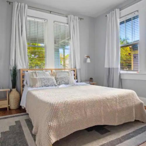 a bedroom with a large bed and two windows at Family Vacation Home in Tampa, Florida in Tampa